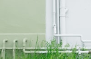 white metal water pipe near grass